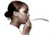 Giirl blowing on a piece of paper